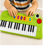 Teclado infantil Fastrok de 37 teclas con diseño de cocodrilo verde, luces LED y botones de funciones musicales.
