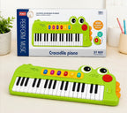 Teclado infantil Fastrok con diseño de cocodrilo verde, 37 teclas, luces LED y funciones musicales educativas.